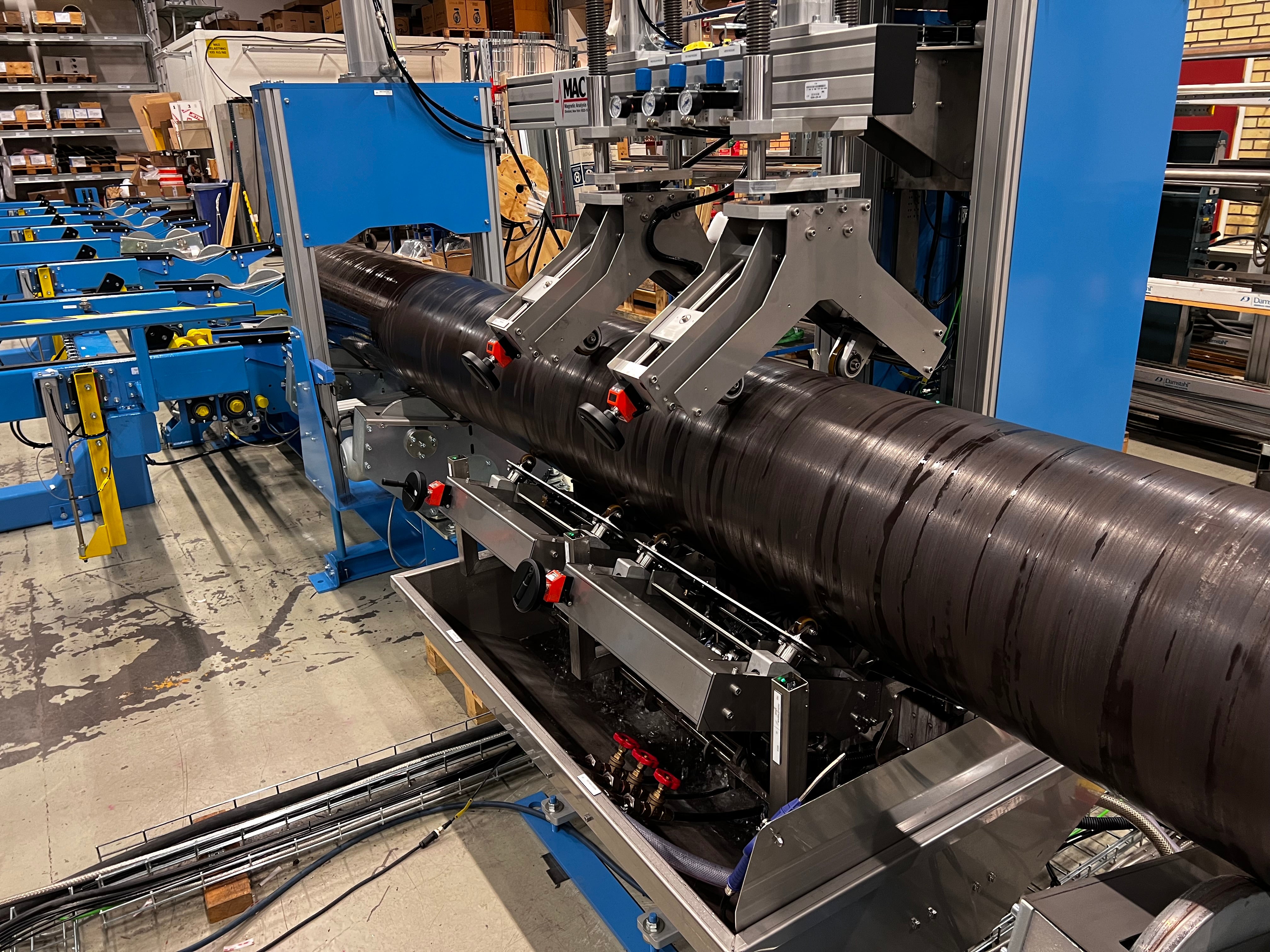 Ultrasonic non destructive testing system, spin-the-tube, large diameter tube product running through a custom ultrasonic test system to detect defects before shipment